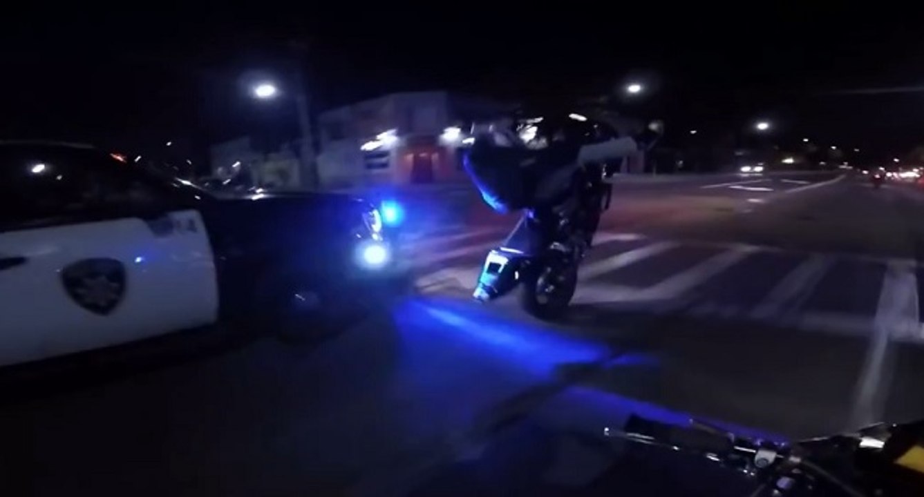 Un motard fait des stunts devant la police