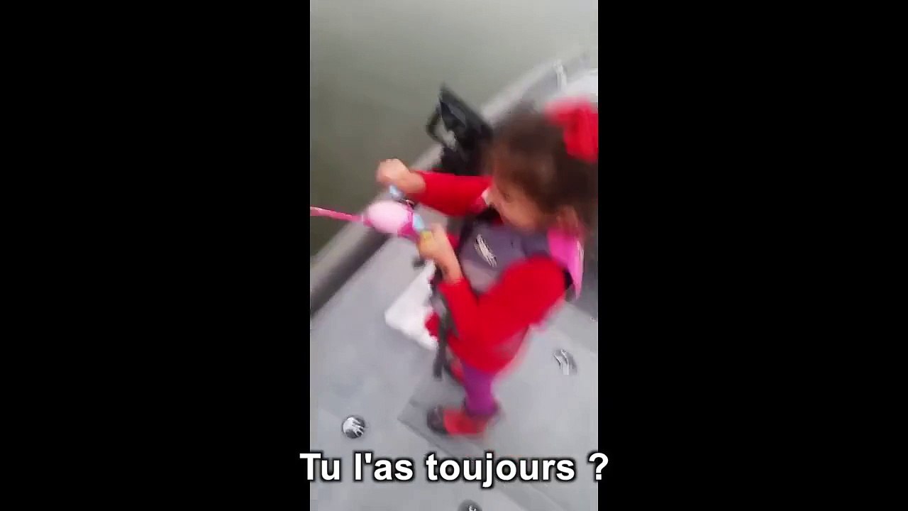 Une petite fille attrape un poisson avec sa canne à pêche barbie