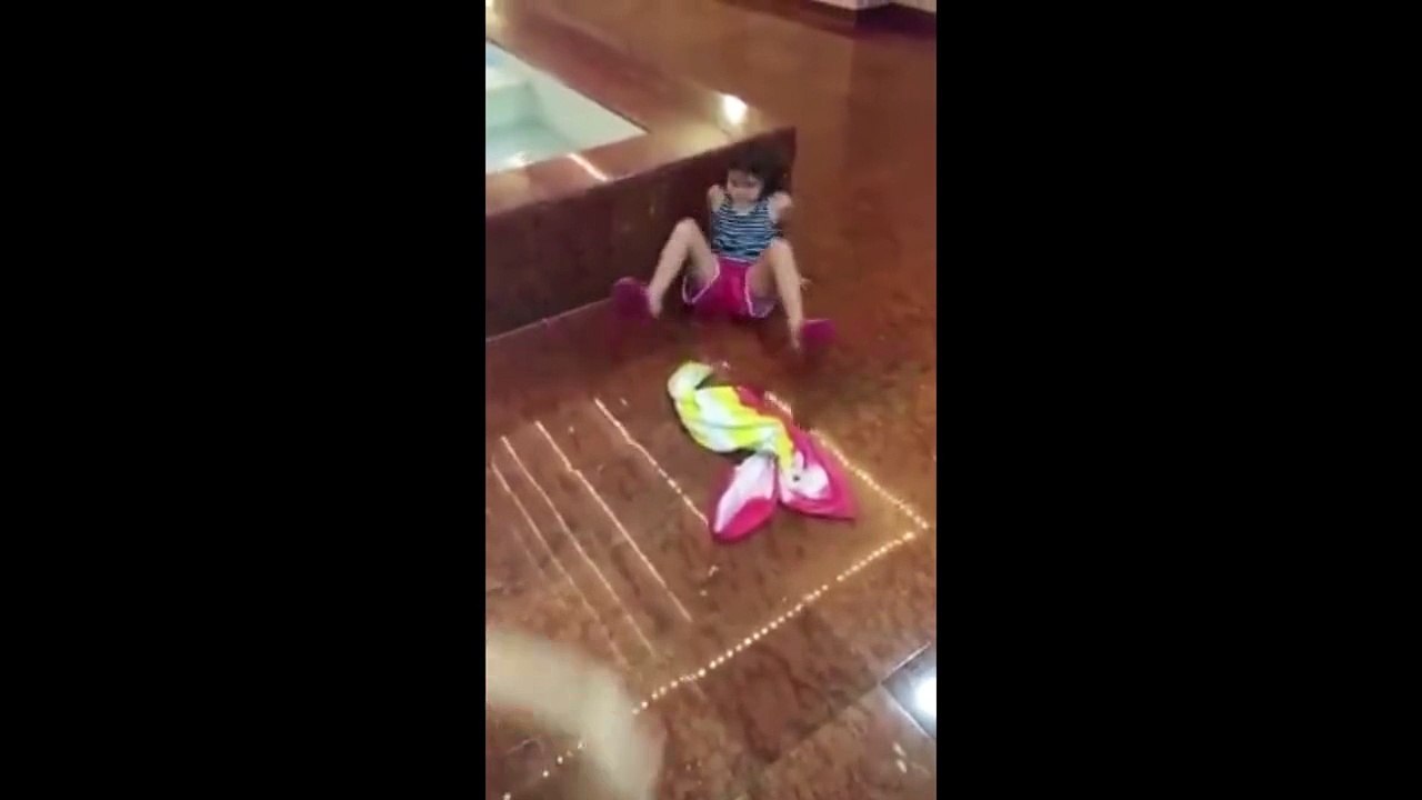 Une petite fille n'arrive pas à se relever... Trop glissant!