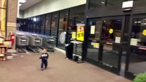 Un gamin en admiration devant des portes automatiques dans un magasin... Adorable