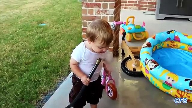 Дети пытаются пить воду из шланга. Забавные дети