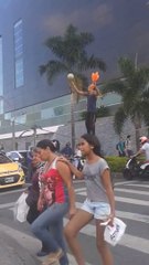Artiste de rue jongle en équilibre sur une corde au milieu de la route à un feu rouge