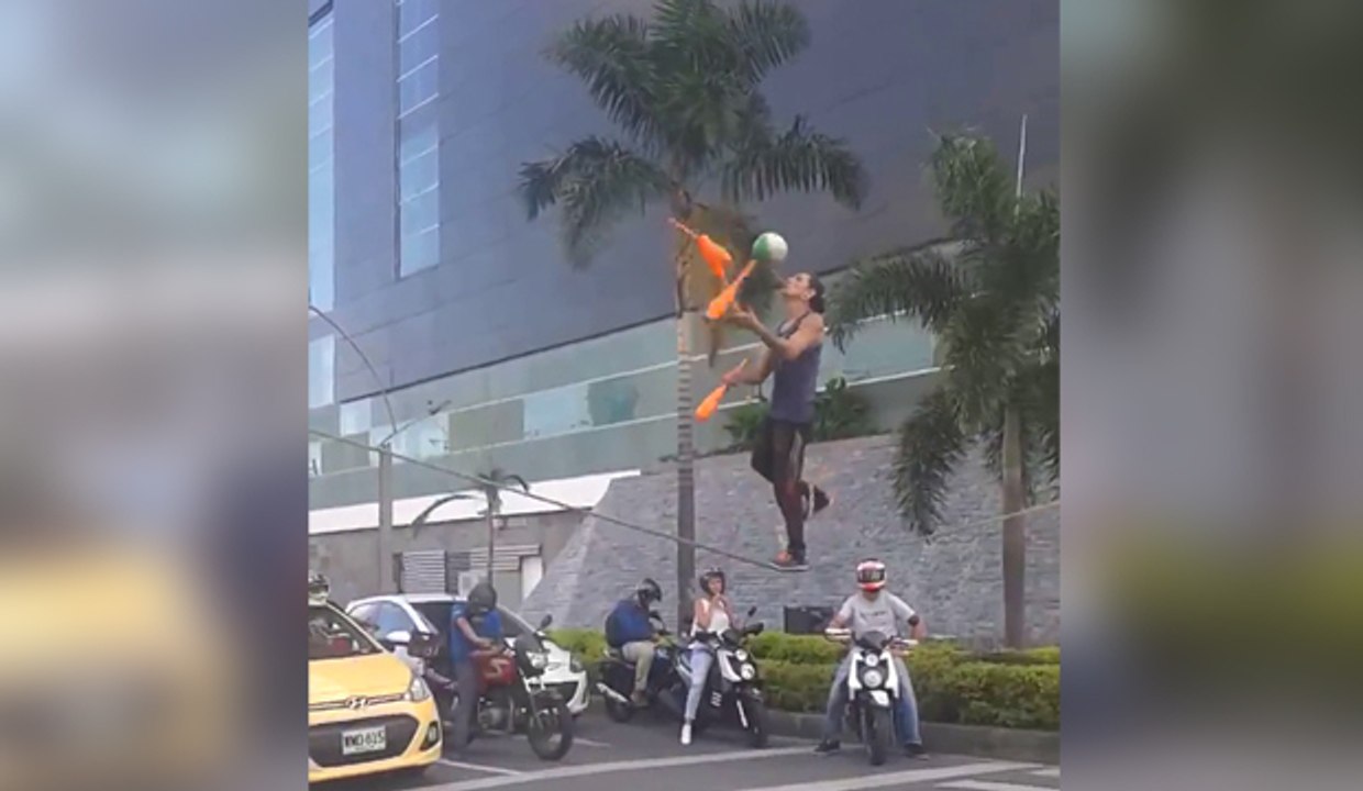 Artiste de rue jongle en équilibre sur une corde