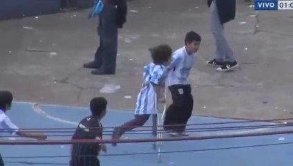 Boy without a leg playing football with other boys during the match Racing Club v Independiente 2015