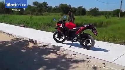 a monkey rides on the bike of a man and fight
