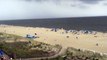 Des parasols emportés par le vent sur une plage