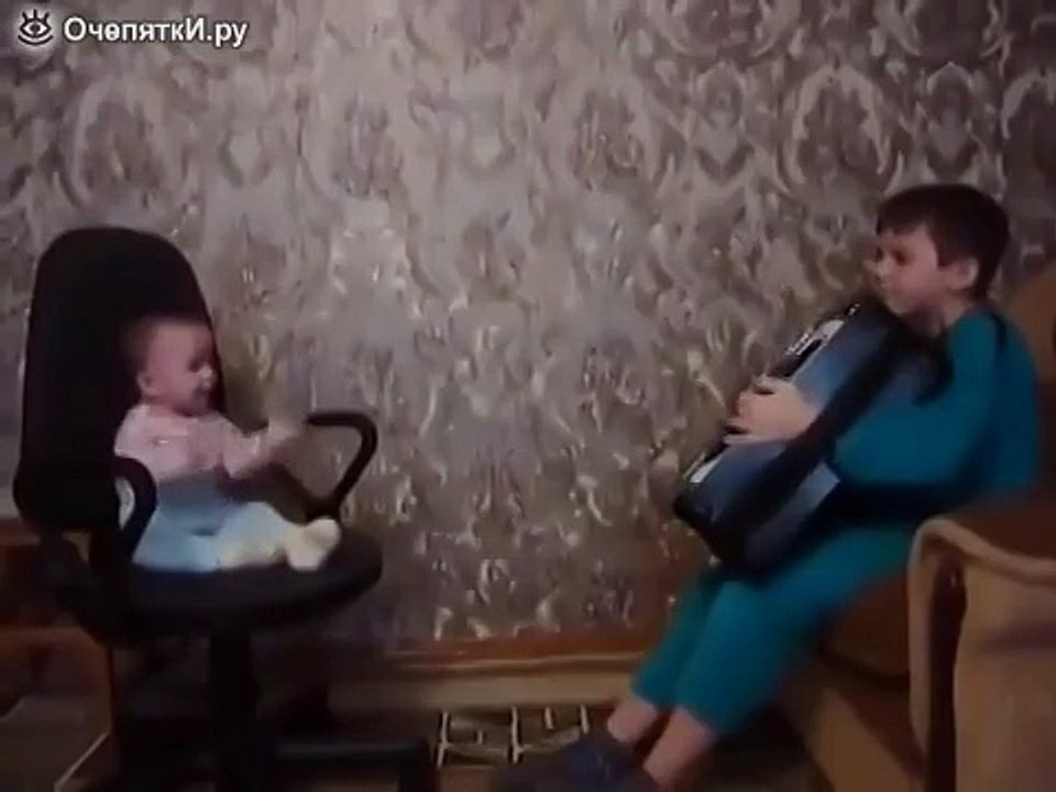 Мальчик баянист играет своему братику