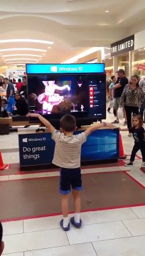 Un petit garçon danse sur Just Dance 2016 dans un centre commercial