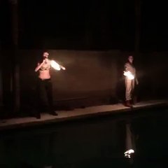Fire blower lights face on fire near pool