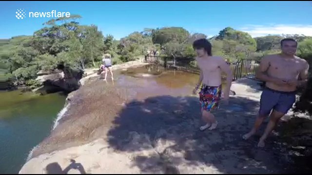 Daredevils jump off high cliff in Australia into lagoon