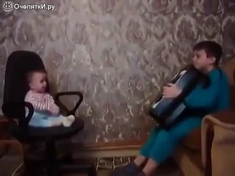 Мальчик баянист играет своему братику
