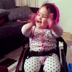 Funny baby enjoying headphone music and dancing