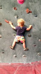 Un bébé de 19 mois esclade un mur indoor avec beaucoup de facilité