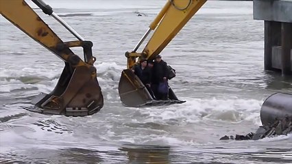 Two excavators are used by the Russians to cross a river.