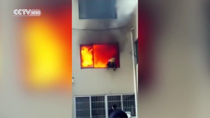 Un pompier en feu saute par la fenetre d'un batiment - plus de peur que de mal