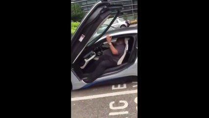 Driver struggling to get out of his low-slung BMW