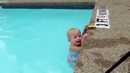 16-month-old baby swimming across a pool by herself.