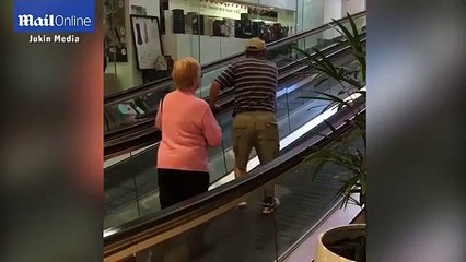 Elderly couple try to walk the WRONG WAY up an escalator in video
