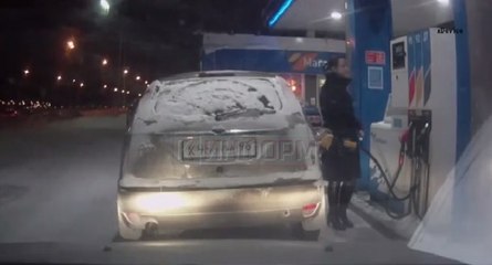 Une femme utilise un briquet dans une station essence en Russie