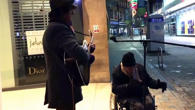 Duo improvisé entre un musicien de rue et un SDF