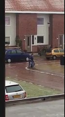 Guy cant put away his garbage because of the ice layered streets.