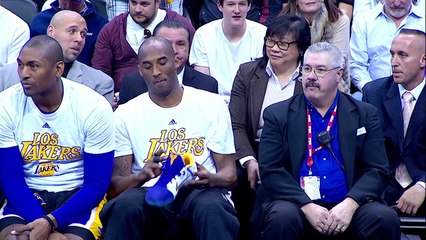 En plein match Kobe Bryant signe ses chaussures pour les donner à un jeune fan