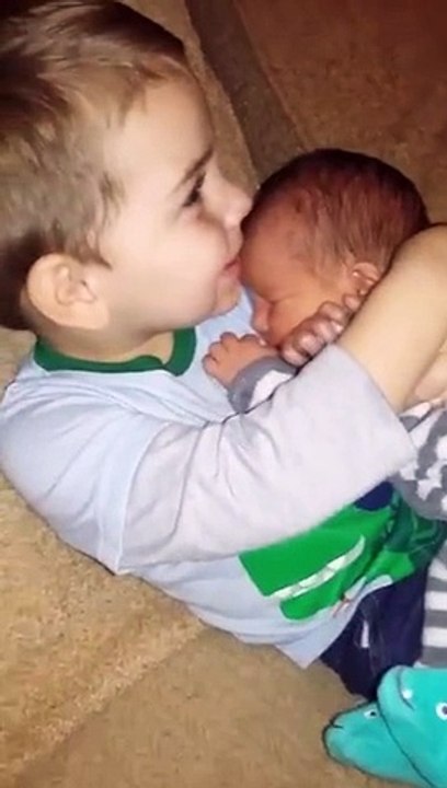 Le plus beau des calins entre un petit garçon et son petit frere qui vient de naitre