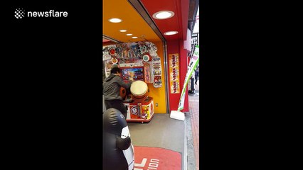 Man rocks out on arcade machine drum-set in hilarious manner