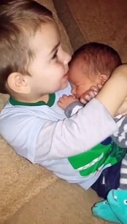 Un enfant fait un tendre câlin à un nouveau-né