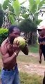 A man peeling a coconut with his teeth