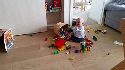 Cute Baby Sitting On The Floor Laughing At Deflating Balloon By His Sister
