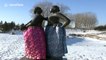 Statues wearing traditional Chinese robes in beautiful, snow-covered park