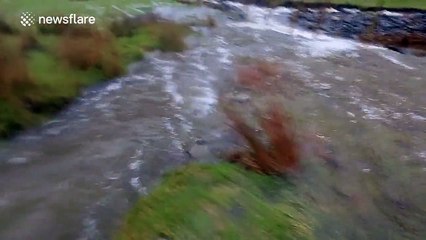 River crashes down Cumbrian fellside spewing rubble as it goes