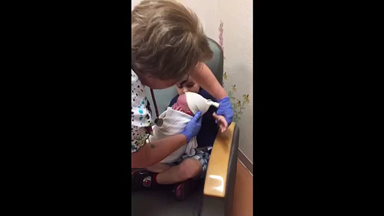 Un enfant porte son petit-frère nouveau né
