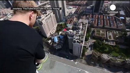 cet homme  défi la mort en se tenant en équilibre sur ses mains au-dessus du vide