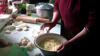 Грузинская хозяйка делает хинкали и хачапури.