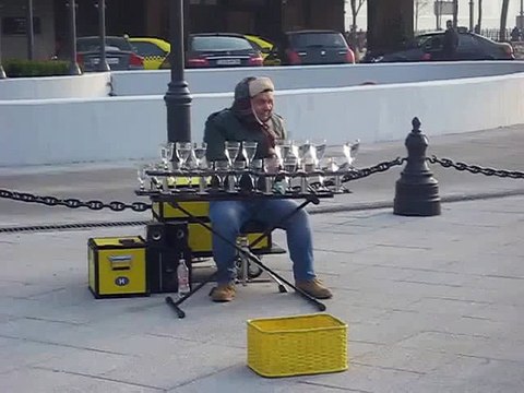Street performer amazingly plays music on water glasses