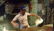 Un pizzaïolo fait des acrobaties avec une pizza