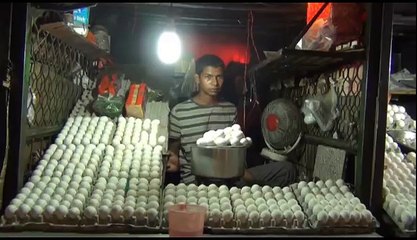 Man cooking Egg Omelette and giving it to customer on bread.