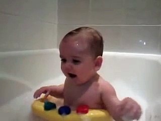 Funny giggling cute baby in bath.