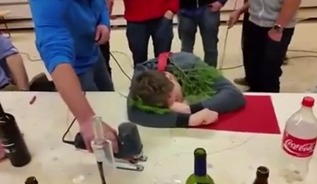 Il découpe une table avec une scie sauteuse pour faire tomber un homme ivre