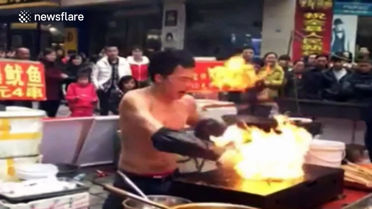 Shirtless man dances wildly while roasting squid