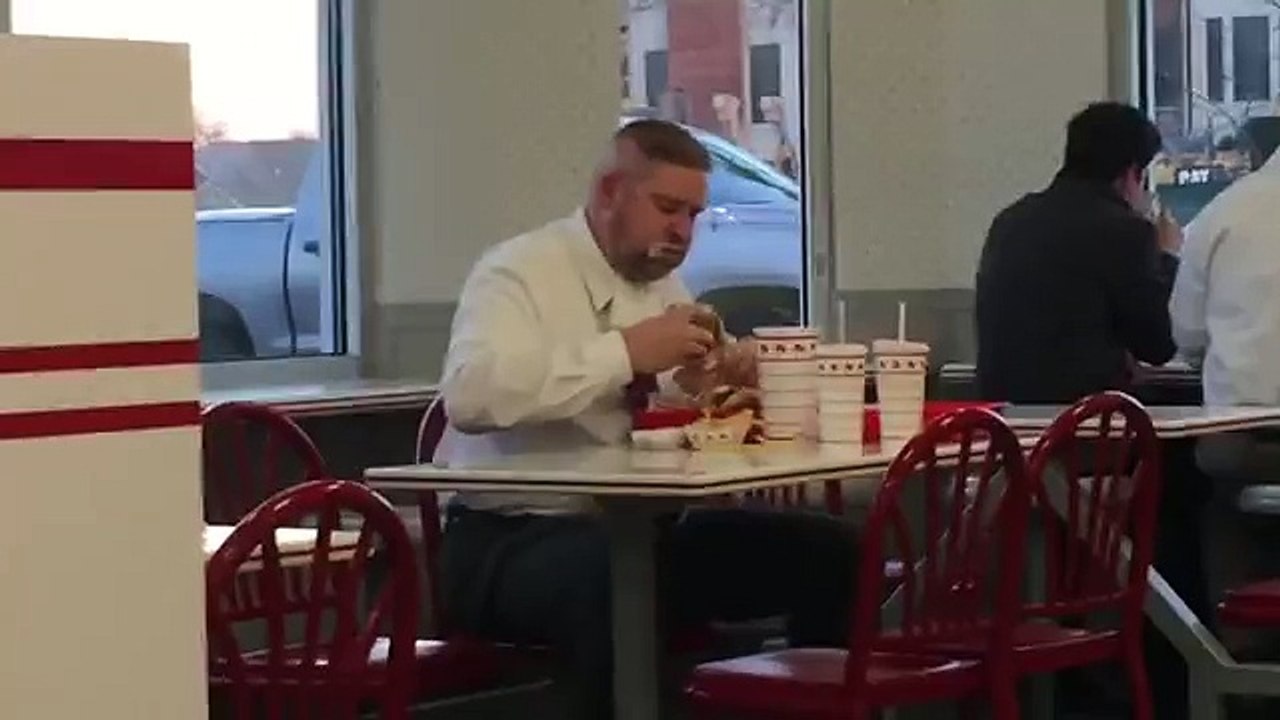 Un homme a une grosse faim dans un fast-food