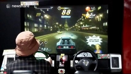 70-year-old woman plays racing game at arcade