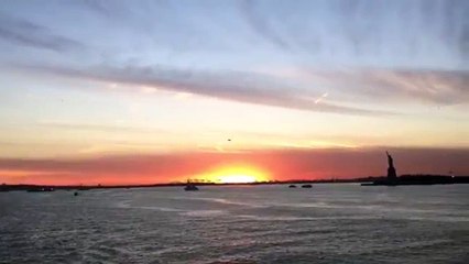 View the sunset from the a ferry at the Hudson River with the Statue of Liberty in the horizon. (News World)