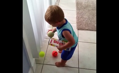 Little Boy Tries To Pick Up Tennis Balls