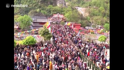 Thousands throw money off bridge to pray for peace