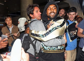 Kanye West breaks up a paparazzi fight with a hug