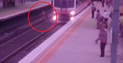 Un idiot traverse une voie ferrée alors qu'un train arrive au même moment