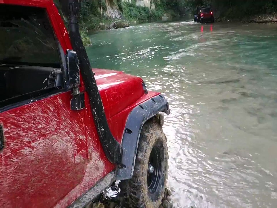 Une Jeep tente de traverser une rivière